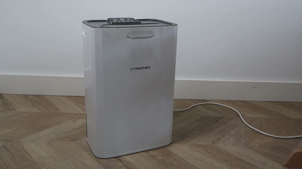 Trotec TTR 57 E adsorptie-luchtontvochtiger op een houten vloer tegen een witte muur